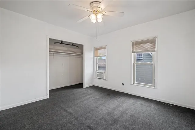 an empty room with windows and closet