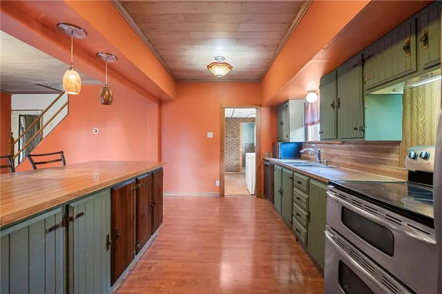 a view of a kitchen with kitchen island a sink a stove and a window