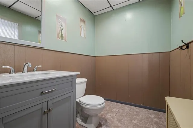 a bathroom with a granite countertop toilet and a sink