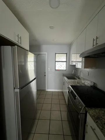 a kitchen with a refrigerator and a stove top oven