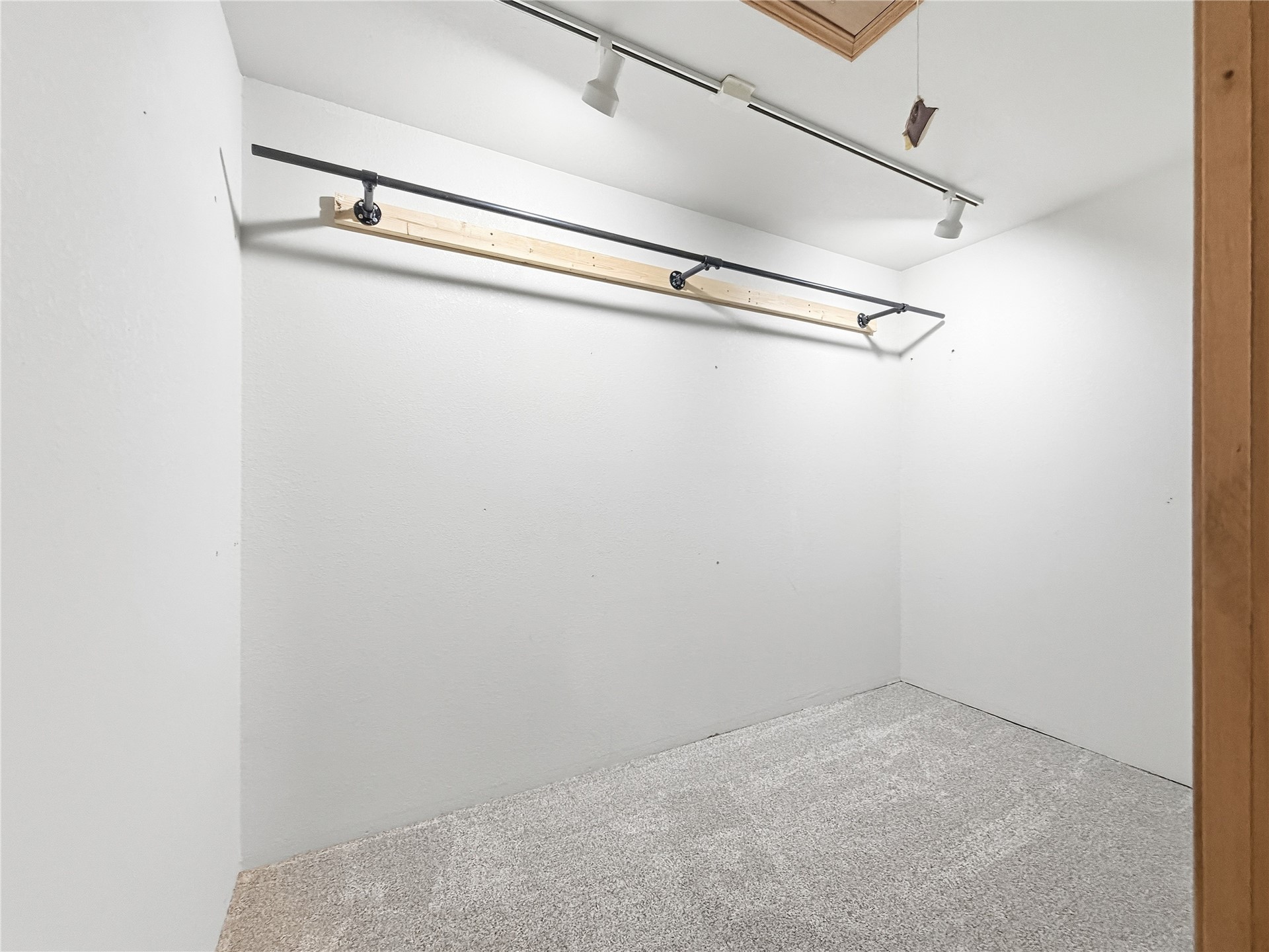 81232 South 4775 Road Stilwell, OK 74960 - Photo 35 of 50 Carpeted flooring with white wall finishes, track lighting, and a garment rod
