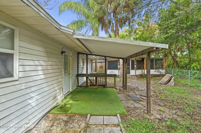 a view of a patio with a table chairs and a barbeque