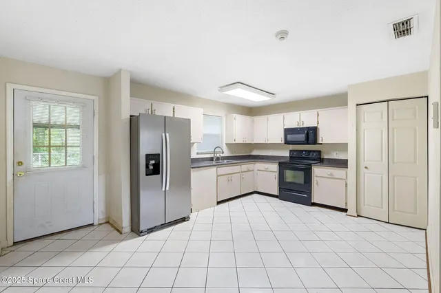 a kitchen with a refrigerator sink and cabinets