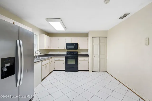 a kitchen with granite countertop a refrigerator and a stove top oven