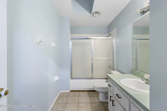 a bathroom with a granite countertop toilet a sink and a shower