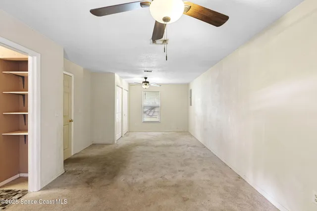 a view of a hallway with a chandelier fan
