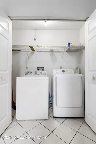 a utility room with a washer dryer and white cabinets
