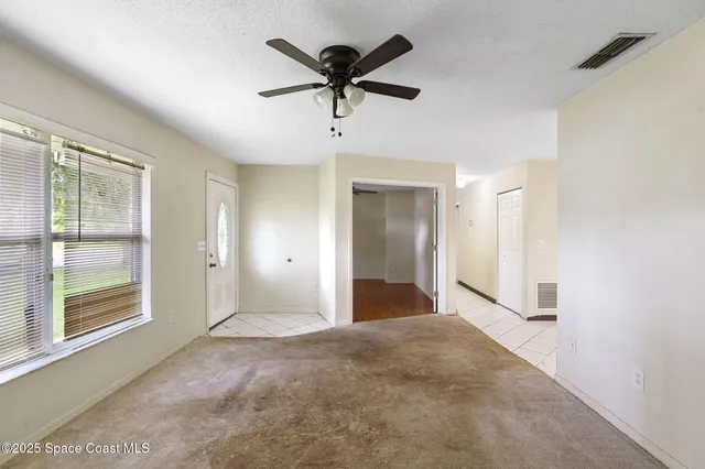 a view of an empty room with a ceiling fan