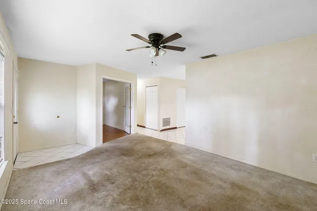 a view of a livingroom with a ceiling fan and window