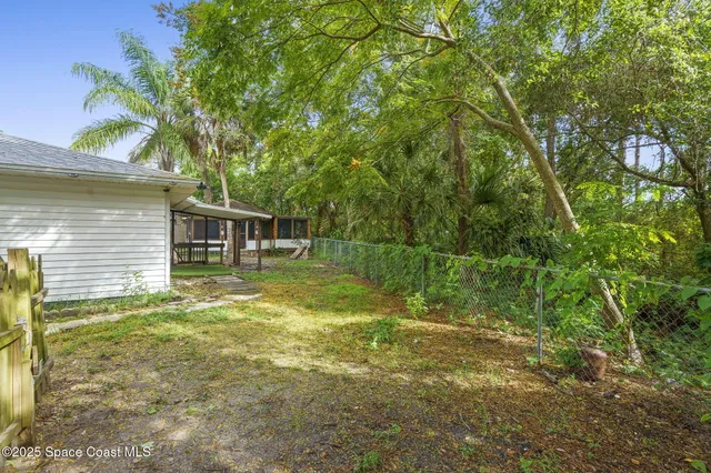 a backyard of a house with table and chairs