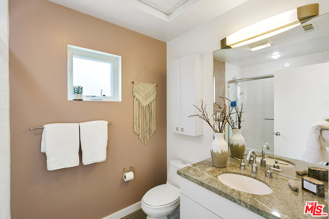 1228 21st Street, Unit D Santa Monica, CA 90404 - Photo 21 of 32 a bathroom with a granite countertop sink toilet and mirror