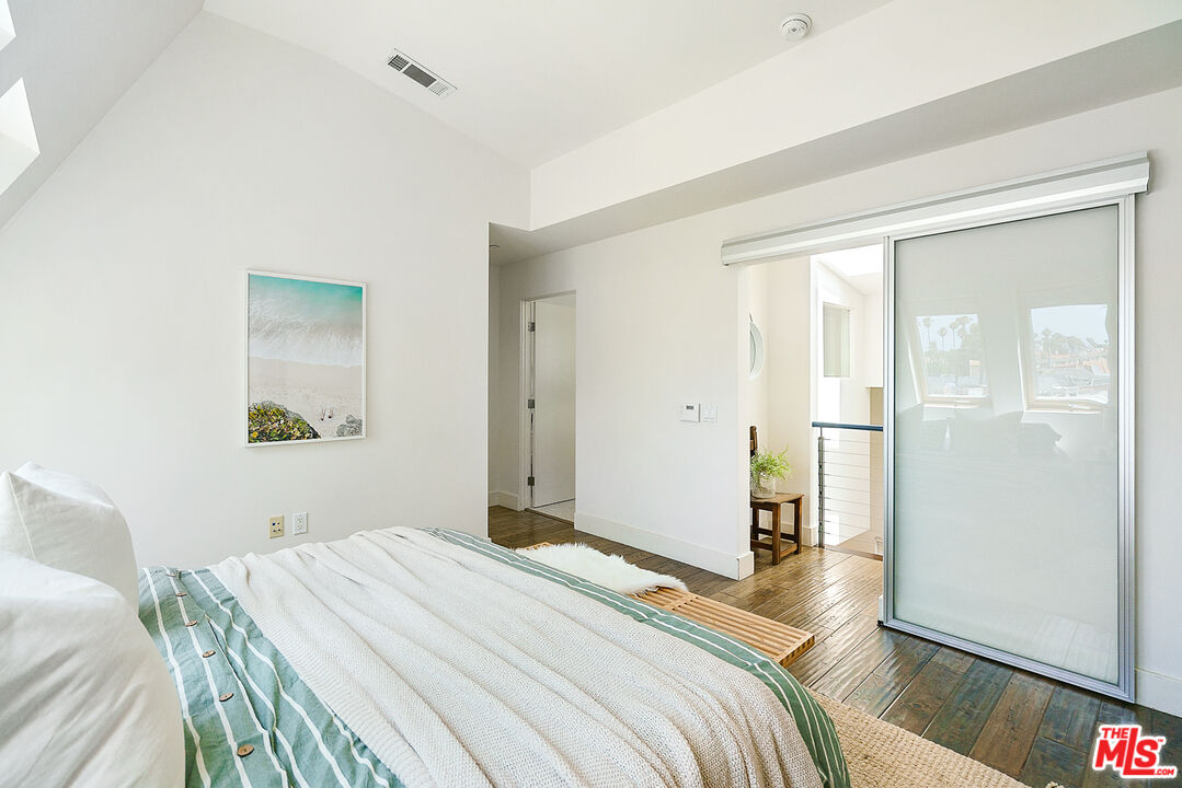 1228 21st Street, Unit D Santa Monica, CA 90404 - Photo 27 of 32 a bedroom with a bed and wooden floor