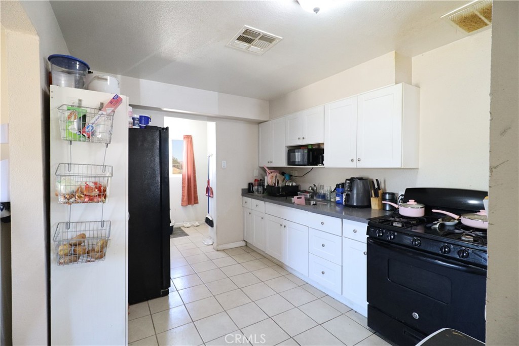 25466 Jasper Road Barstow, CA 92311 - Photo 12 of 32 a kitchen with stainless steel appliances granite countertop a refrigerator and a stove top oven