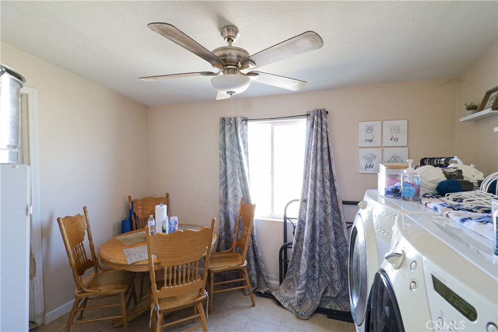 25466 Jasper Road Barstow, CA 92311 - Photo 15 of 32 a view of a dining room with furniture and a chandelier fan