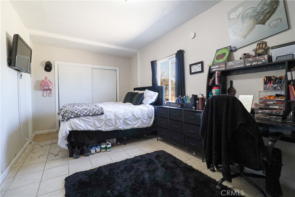 25466 Jasper Road Barstow, CA 92311 - Photo 28 of 32 a bedroom with a bed and a mirror