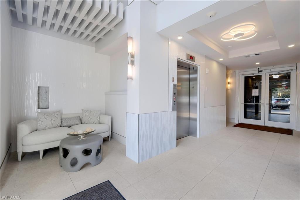 400 Flagship Drive, Unit 705 Naples, FL 34108 - Photo 13 of 25 a living room with furniture and a glass door shower