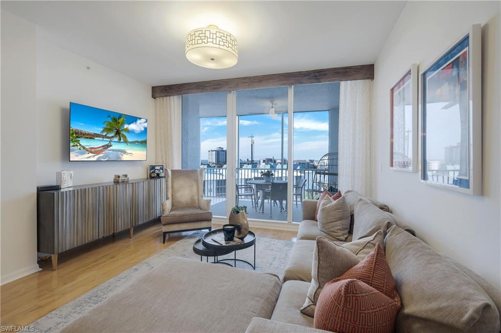 400 Flagship Drive, Unit 705 Naples, FL 34108 - Photo 3 of 25 a living room with furniture a floor to ceiling window and a flat screen tv