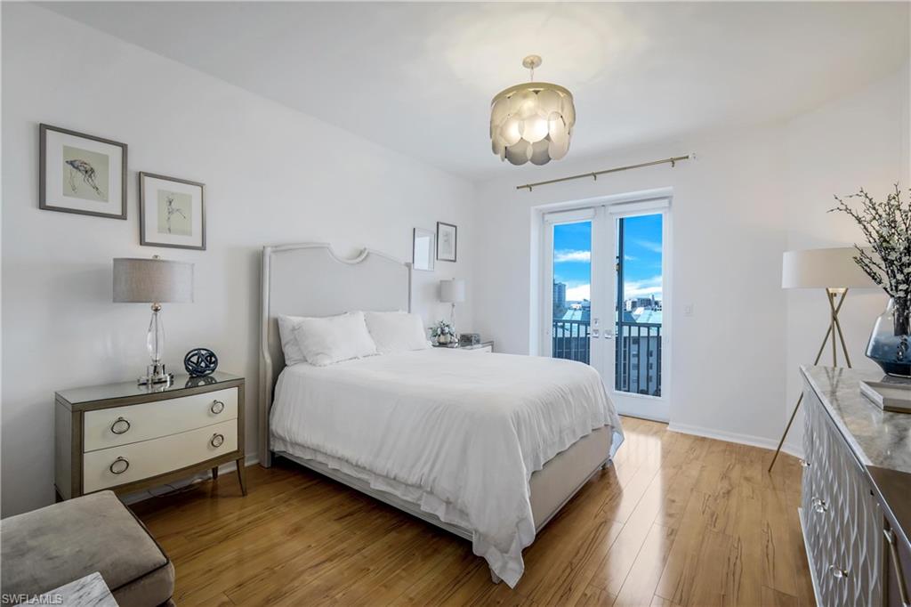 400 Flagship Drive, Unit 705 Naples, FL 34108 - Photo 6 of 25 a bedroom with a bed and a chandelier