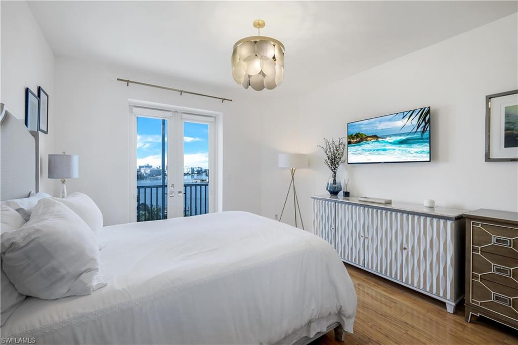 400 Flagship Drive, Unit 705 Naples, FL 34108 - Photo 7 of 25 a bedroom with a bed and a chandelier