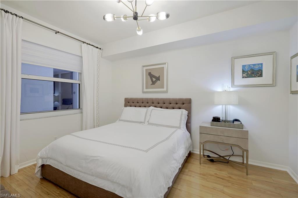 400 Flagship Drive, Unit 705 Naples, FL 34108 - Photo 9 of 25 a bedroom with a bed and a lamp on table