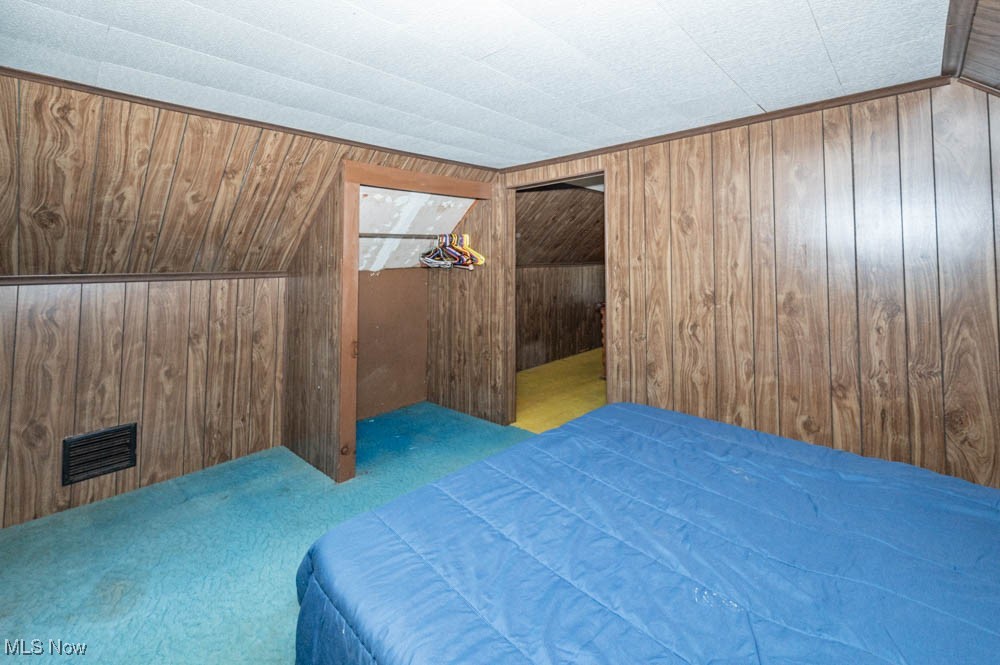 103 Valley Road Damascus, OH 44619 - Photo 20 of 27 Carpeted bedroom featuring wood walls and lofted ceiling
