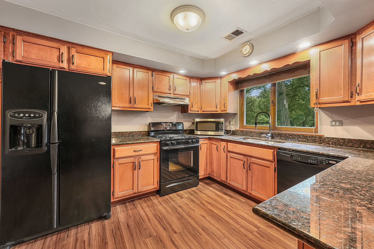 27960 South Klemme Road Beecher, IL 60401 - Photo 6 of 24 a kitchen with stainless steel appliances granite countertop a refrigerator a sink dishwasher a stove and white countertops with wooden floor