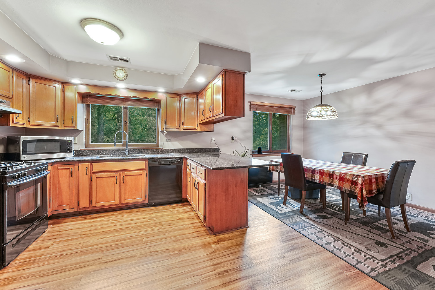 27960 South Klemme Road Beecher, IL 60401 - Photo 7 of 24 a kitchen with stainless steel appliances granite countertop wooden floors a stove a sink and a refrigerator