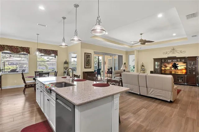 a large kitchen with kitchen island a stove a sink a center island a dining table and chairs