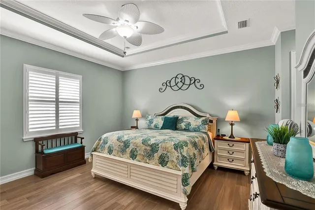 a bedroom with a bed chandelier and a window