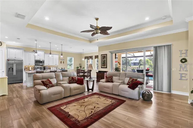 a living room with furniture kitchen view and a wooden floor