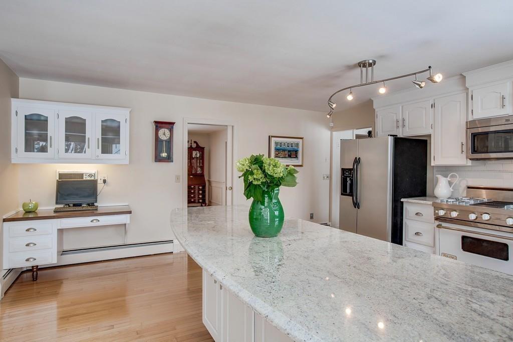 12 Rutgers Road Andover, MA 01810 - Photo 8 of 40 a kitchen with stainless steel appliances kitchen island granite countertop a refrigerator a stove a sink dishwasher and white cabinets with wooden floor