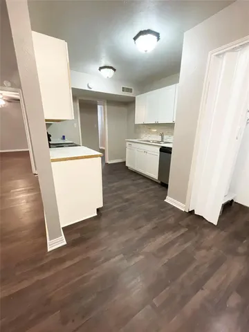 a kitchen with sink a refrigerator and white stove top oven