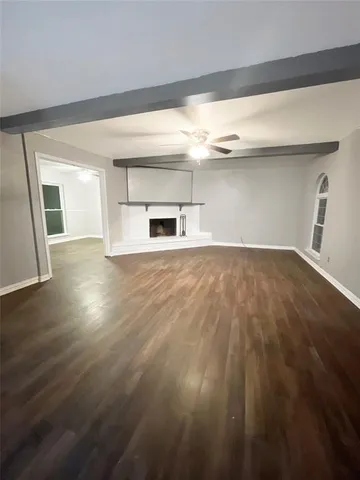 a view of empty room with wooden floor and fireplace
