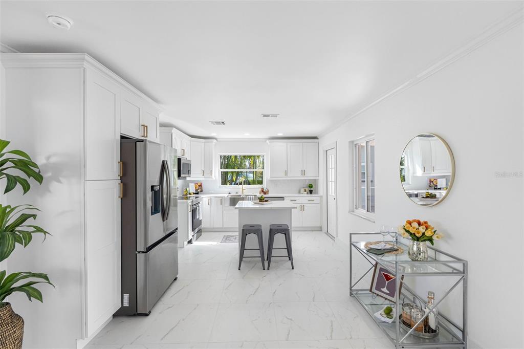 785 115th Avenue Treasure Island, FL 33706 - Photo 16 of 46 a kitchen with a refrigerator and a dining table