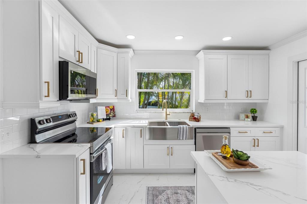 785 115th Avenue Treasure Island, FL 33706 - Photo 19 of 46 a kitchen with a stove a sink and a microwave