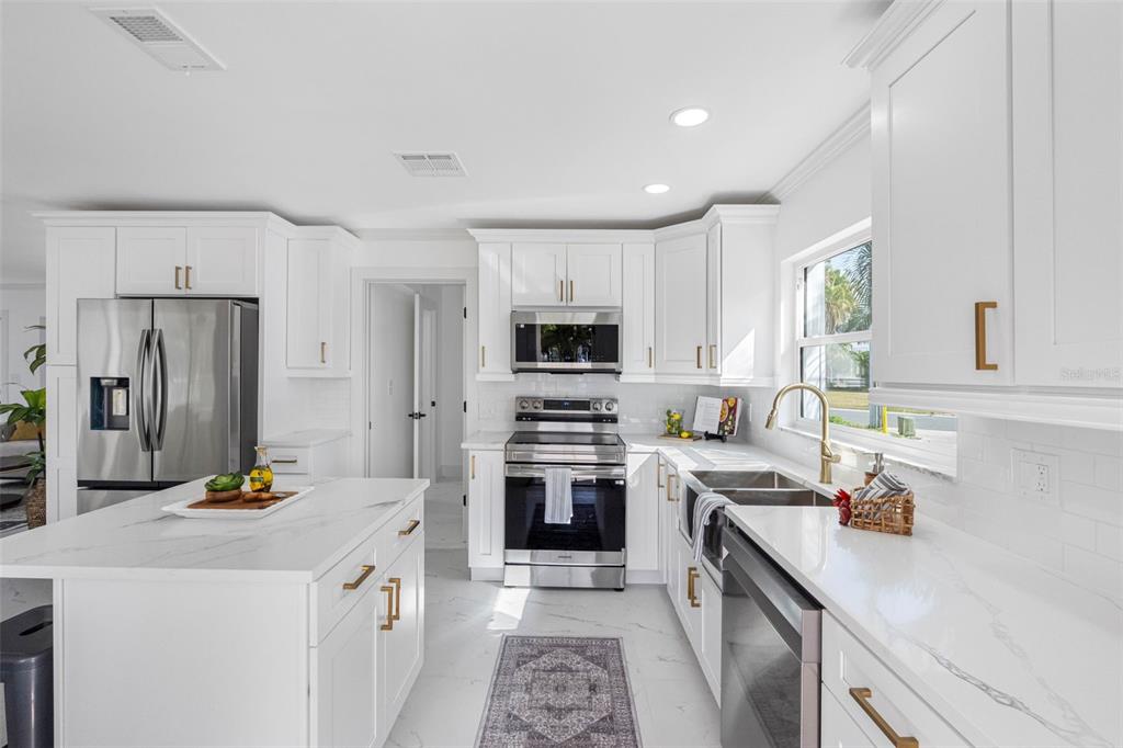 785 115th Avenue Treasure Island, FL 33706 - Photo 21 of 46 a kitchen with a sink stove and refrigerator