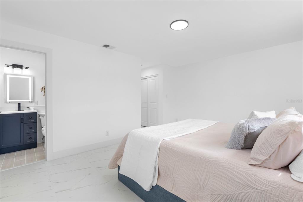 785 115th Avenue Treasure Island, FL 33706 - Photo 25 of 46 a bedroom with a bed and a mirror