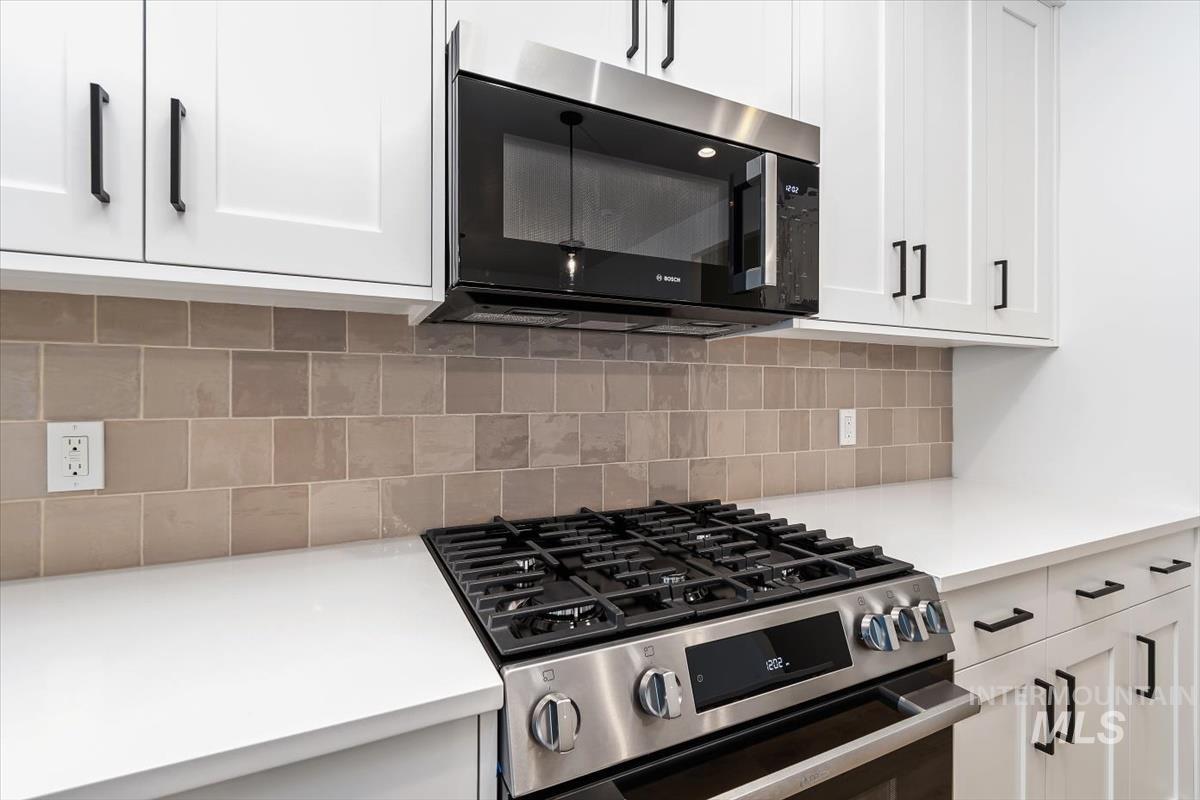 736 South Calhoun Lane Star, ID 83669 - Photo 12 of 42 Kitchen view of white cabinets, stainless steel appliances, and backsplash