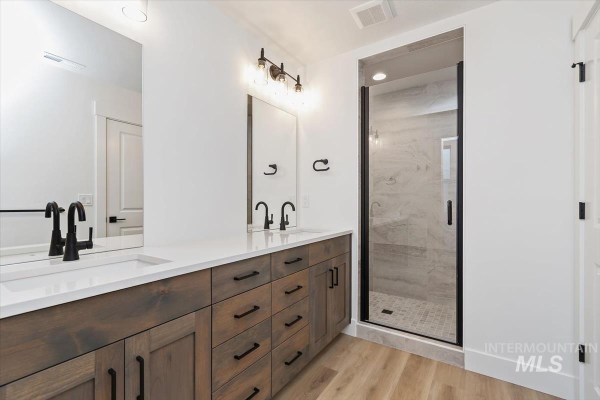 736 South Calhoun Lane Star, ID 83669 - Photo 26 of 42 Full bathroom with double vanity, a marble finish shower, and light wood finished floors