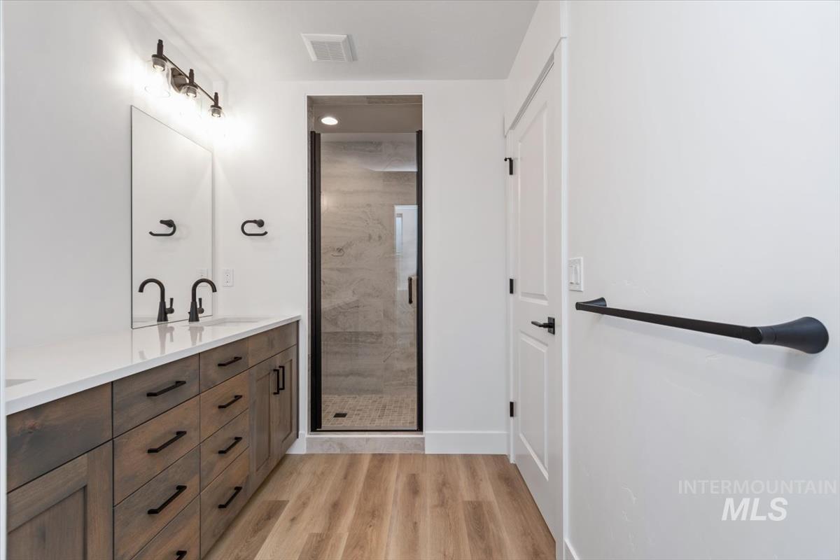 736 South Calhoun Lane Star, ID 83669 - Photo 27 of 42 Full bath featuring a shower stall, double vanity, and light wood-style flooring