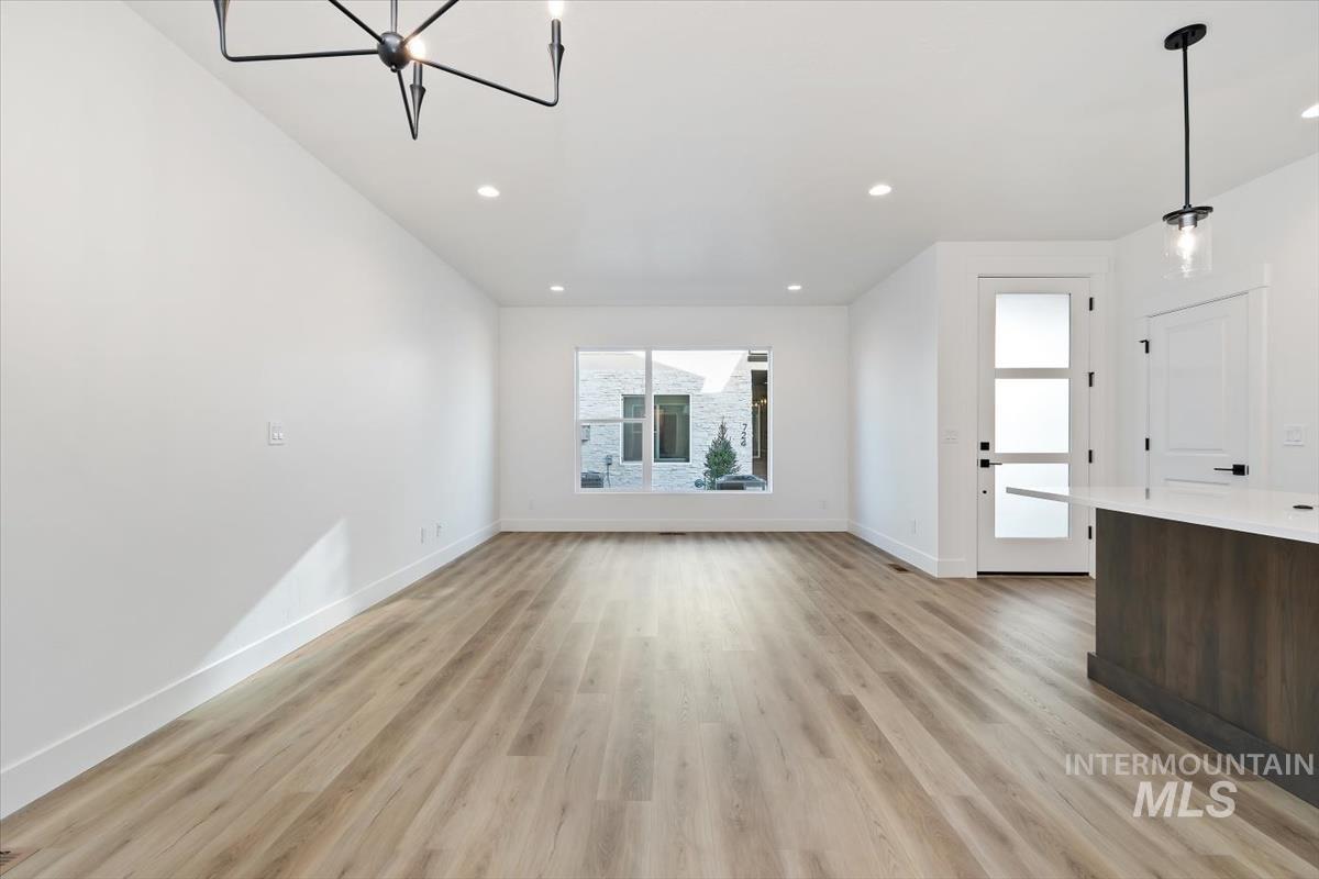 736 South Calhoun Lane Star, ID 83669 - Photo 5 of 42 Unfurnished living room featuring light wood-style flooring and hanging lights