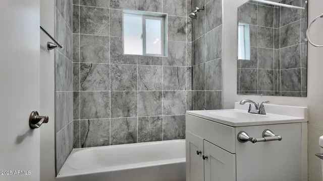 a bathroom with a sink mirror and shower