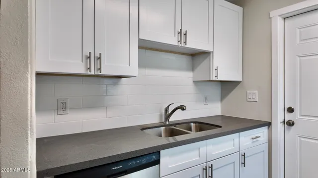 a kitchen with white cabinets and a sink