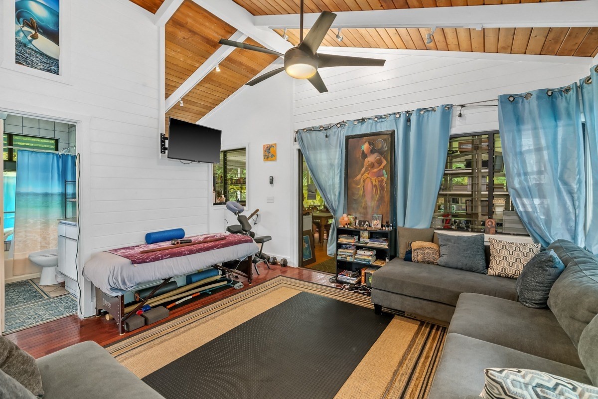 6384 Makana Road, Unit 2 Kapaa, HI 96746 - Photo 9 of 25 a living room with furniture gym equipment and large windows