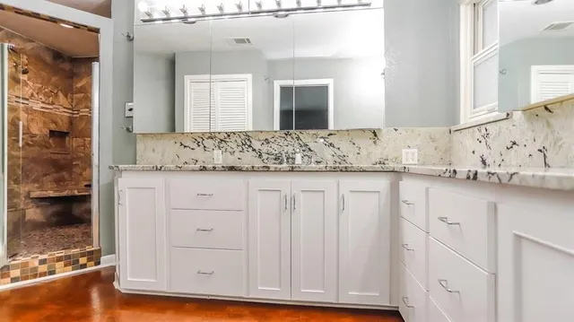 a bathroom with a granite countertop sink and a mirror