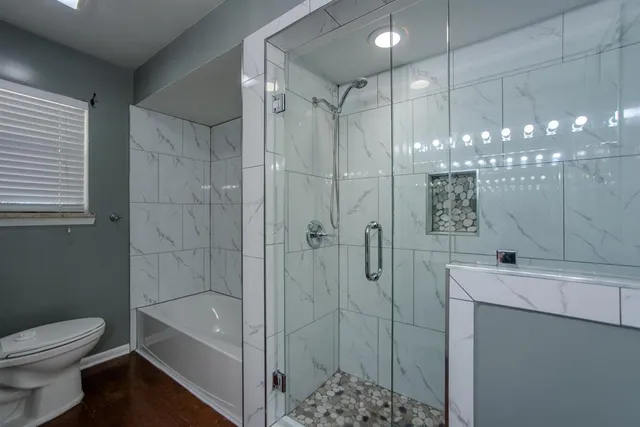 a bathroom with a bathtub a toilet a sink and shower