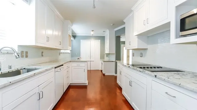 a kitchen with granite countertop cabinets stainless steel appliances a sink and a counter top space