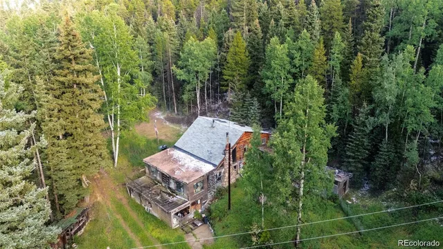 aerial view of a house with a yard and sitting area