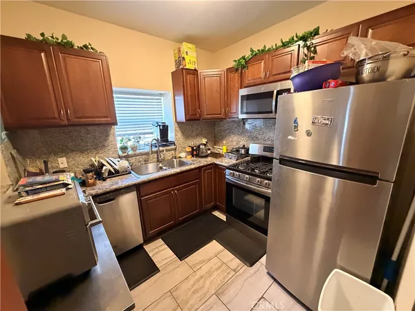 a kitchen that has a refrigerator a sink and a stove