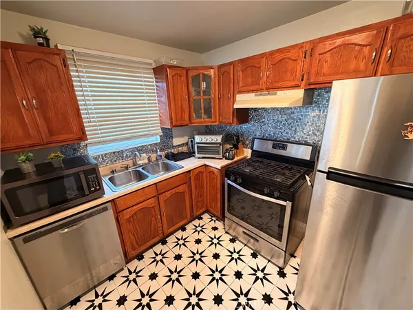 a kitchen with stainless steel appliances a refrigerator sink and stove